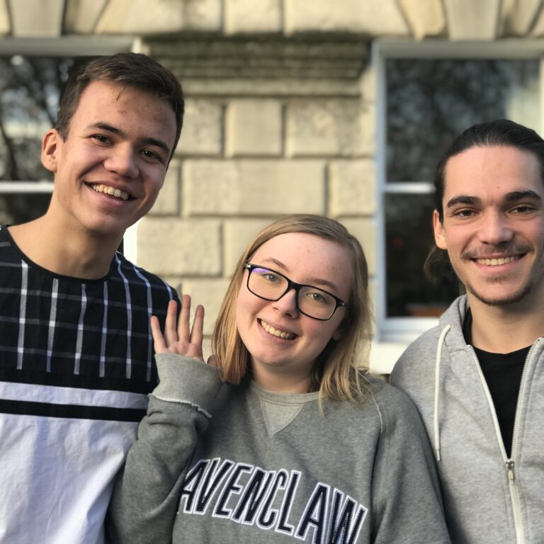 students smiling and waving